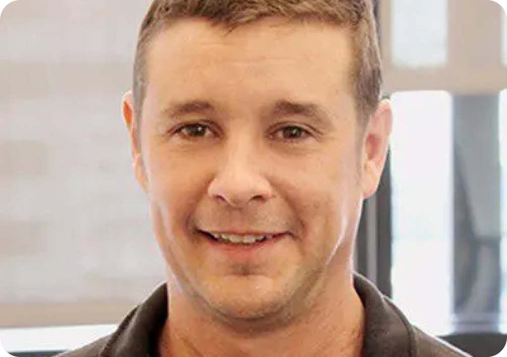 Bob Mayes Photo Light brown haired man smiling in a dark brown collared shirt.